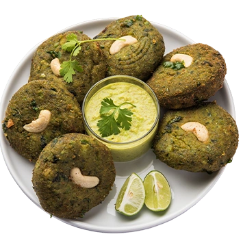 A green hara bhara kababs on a plate, garnished with cashews and cilantro served at a north indian restaurant